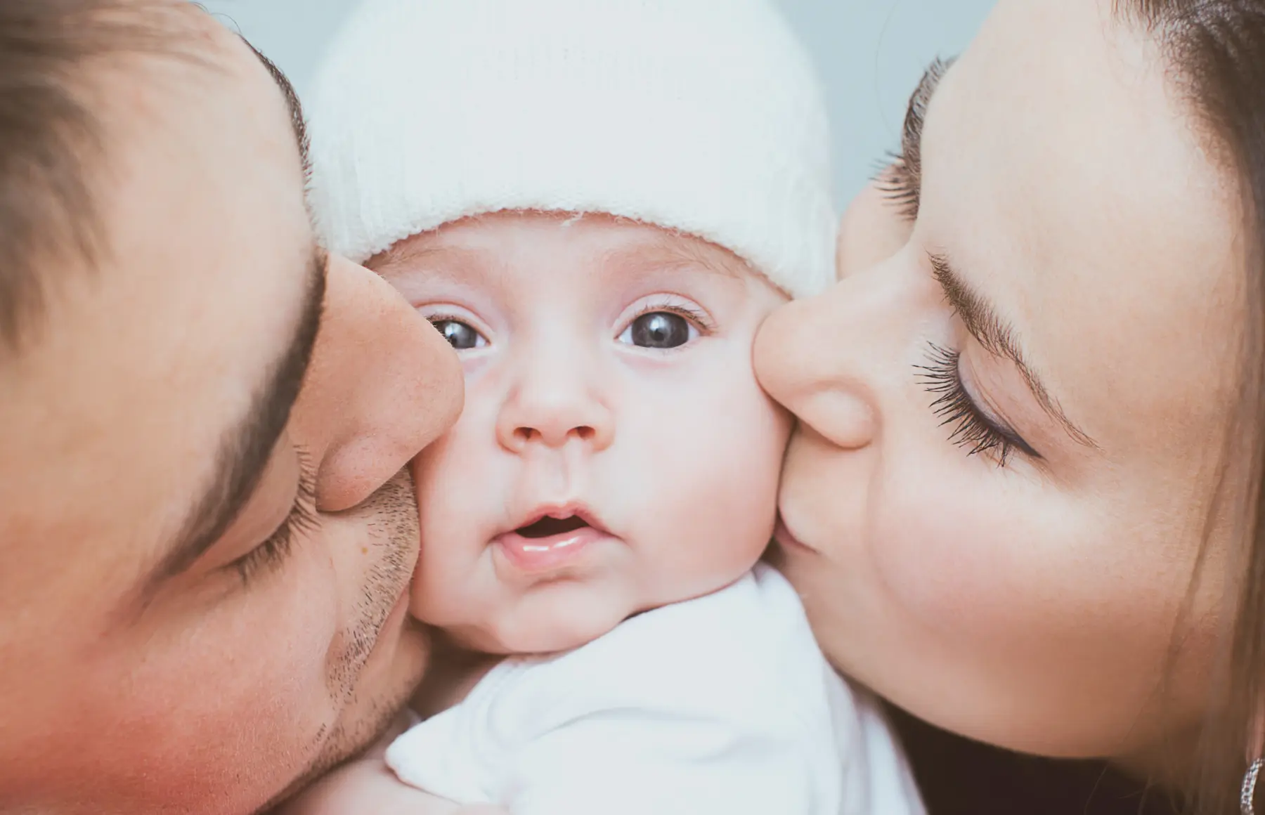 eltern küssen ihr baby